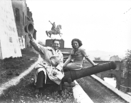 Aktorzy Eugeniusz Bodo i Nora Ney na wzgórzu wawelskim siedzą na lufie armatniej. W głębi widoczny pomnik Tadeusza Kościuszki.